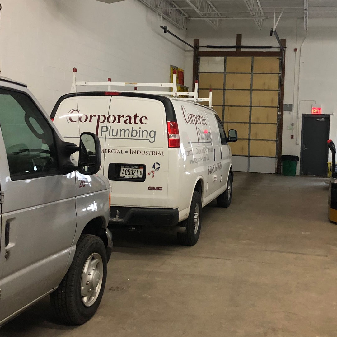 Corporate Plumbing Vans in the shop ready to depart for the workday.
